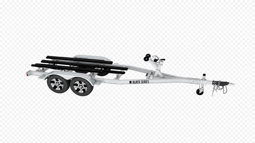 Side view of a 25 ft tandem axle aluminum boat trailer with black bunk boards and winch stand